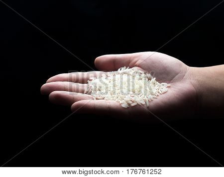 Rice on hand on a back background