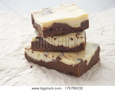 Marble chocolate brownies closeup. Homemade dessert. Stack of freshly baked brownie cheesecake. Selective focus on the front.