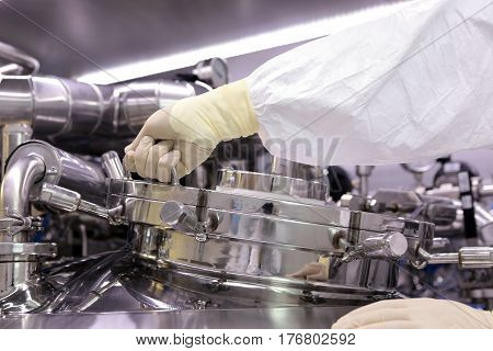 A Man Opens A Chemical Reactor. Rector Of The Pharmaceutical Industry. The Man Closes The Reactor. P