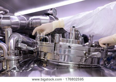 A Man Opens A Chemical Reactor. Rector Of The Pharmaceutical Industry. The Man Closes The Reactor. P
