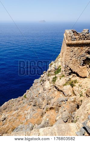 The view from the walls of the dilapidated old stone fortress of the turquoise sea and the distant horizon