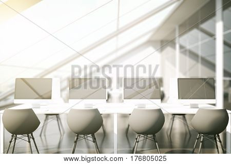 Front view of modern coworking office with multiple blank computers. Toned image. Mock up 3D Rendering