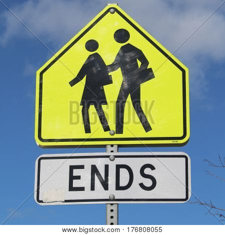 Closeup of yellow black and white traffic sign for school zone end.