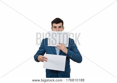 Portrait of a smiling businessman holding two white papers one hiding half face on a white background.