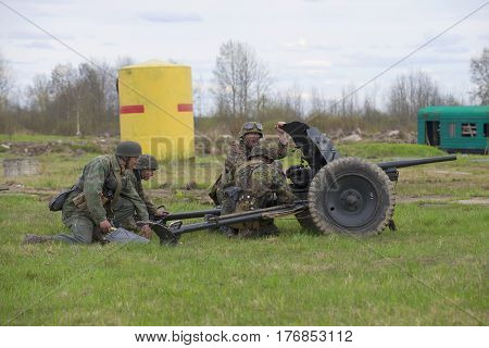 LENINGRAD REGION, RUSSIA - MAY 05, 2015: German soldiers firing from anti-tank guns. Reconstruction of the episode of the great Patriotic war