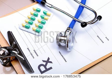 RX prescription, Red heart, asorted pils and a stethoscope on white background.
