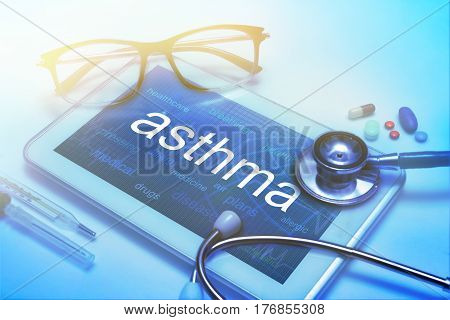 Asthma word on tablet screen with medical equipment on background