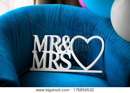 Beautiful wedding Mr and Msr label with heart on blue armchair, closeup