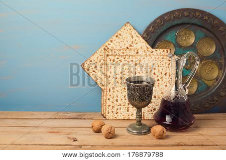 Jewish holiday Passover concept with wine matza and seder plate on wooden table