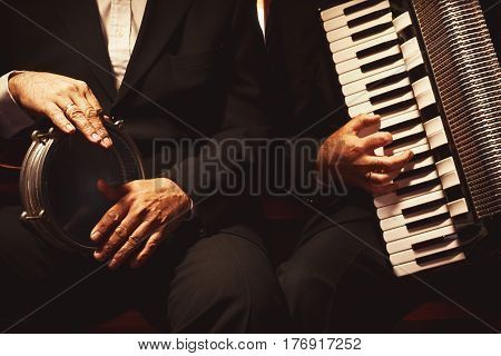 Two Musicians On Their Instruments