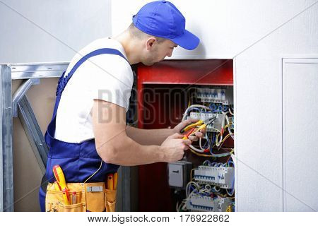 Electrician connecting wires in distribution board