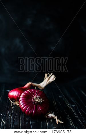 Red onions on a dark background vertical .place for text