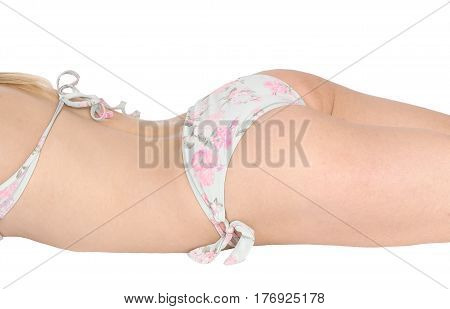 The bottom of a young woman in a light blue bikini lying on her stomach on the floor isolated for white background.