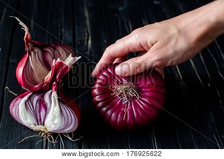 Red sliced onion on dark wooden background. close up