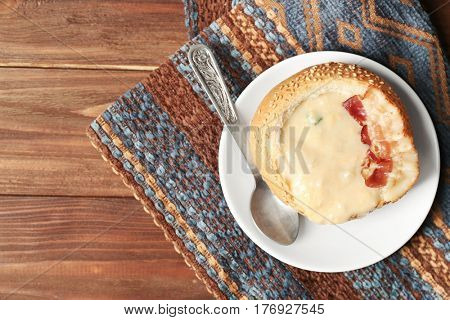 Delicious cream soup in bread on table