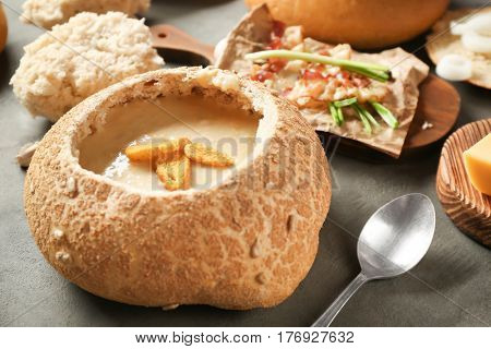 Delicious cream soup in bread on table