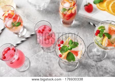 Glasses of delicious wine spritzer on grey table