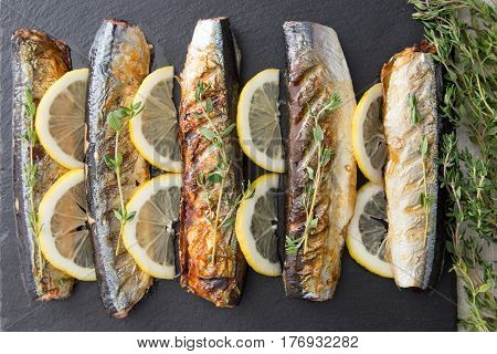 Grilled Fish Saury With Lemon On A Slate Board