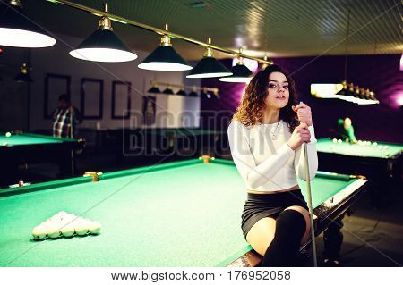 Young Curly Girl Posed Near Billiard Table. Sexy Model At Black Mini Mini Skirt Play Russian Snooker
