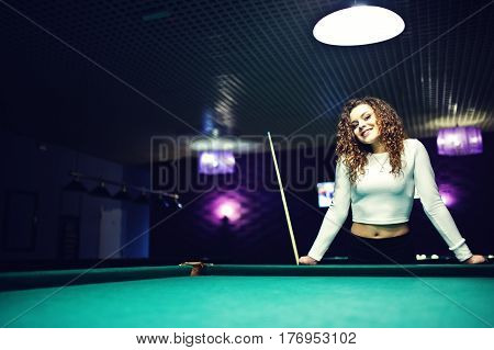 Young Curly Girl Posed Near Billiard Table. Sexy Model At Black Mini Mini Skirt Play Russian Snooker