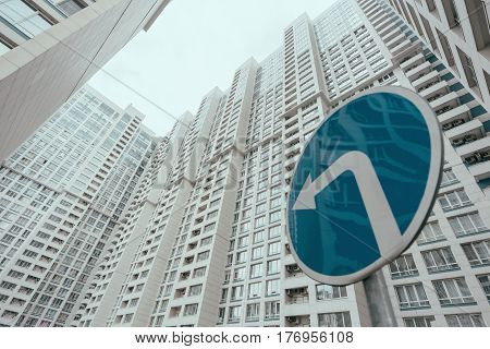 View from bottom of modern contemporary white skyscraper apartment building with regular windows and balconies on bright day with blue 