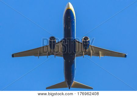 a blue passenger commercial jet plane isolated against the blue sky, taking off blow view.