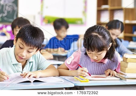 asian primary school students studying in classroom.
