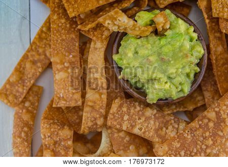 Close up Bowl of Guacamole with Chips Filling Frame