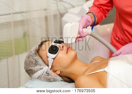 Laser hair removal on the face of a young girl. Apparatus cosmetology. Cosmetic procedures. Spa. Removing hair from the upper lip.
