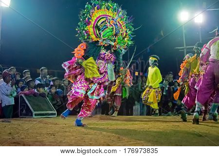 BAMNIA PURULIA WEST BENGAL INDIA - DECEMBER 23RD 2015 : Masked Dancers performing at Chhau Dance festival at night. Shot under colored light. It is a popular local Indian tribal martial dance based on Hindu myth.