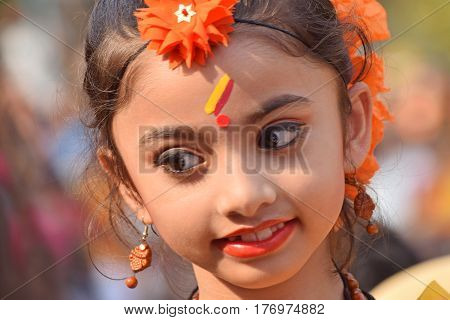 KOLKATA INDIA - MARCH 12 2017: Young girl with spring festive make up with flowers joyful expression at Holi/Spring festivalknown as Dol (in Bengali) or Holi (in Hindi) celebrating arrival of Spring in India.