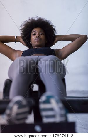 young fit african american woman doing sit ups in fitness studio at the gym.Abdominal exercises Sit up