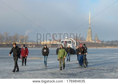 SAINT PETERSBURG, RUSSIA - MARCH 12, 2017: Employees of EMERCOM of Russia on the rescue ship Khivus-20 forbid people to go out on the melted ice on the frozen Neva river on a March day