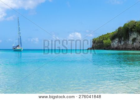 Yacht Moored At Anse Canot Bay, Marie Galante, Guadeloupe, With Turquoise Sea And Quiet Atmosphere