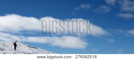 Blue Sky And Skier With Skis On His Shoulder Go Up To Top Of Mountain. Caucasus Mountains In Winter,