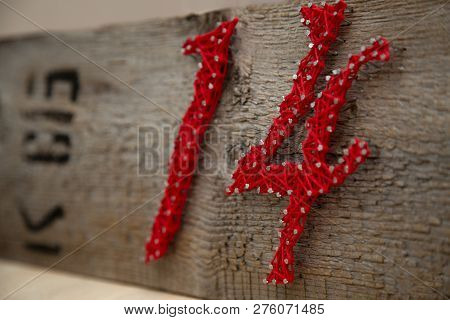 Number 14 In Red Threads On An Old Dry Board