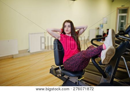 Young Sport Girl Workout In Gym. Fitness Woman Doing Exercises On Stationary Bicycle.