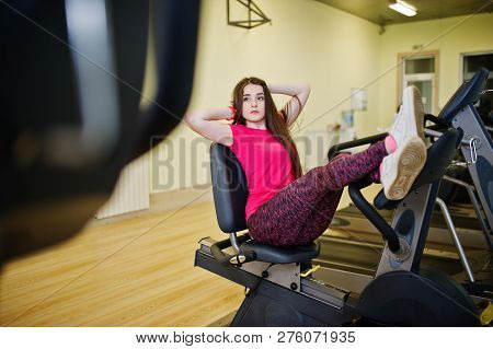 Young Sport Girl Workout In Gym. Fitness Woman Doing Exercises On Stationary Bicycle.
