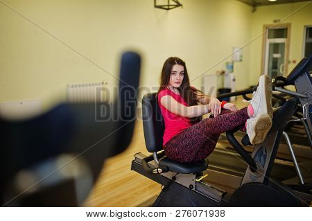 Young Sport Girl Workout In Gym. Fitness Woman Doing Exercises On Stationary Bicycle.