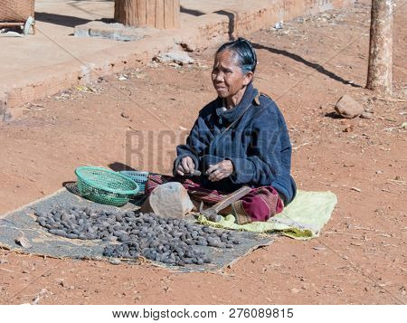 near pakse, laos - 11 24, 2018: woman sells nuts