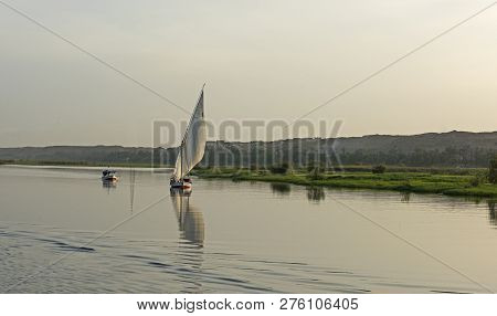 Traditional Egyptian Felluca Sailing Boat On River Nile With Reflection At Aswan