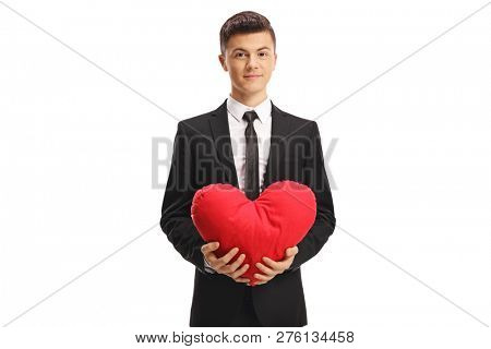 Young handsome man in a suit holging a red heart isolated on white background