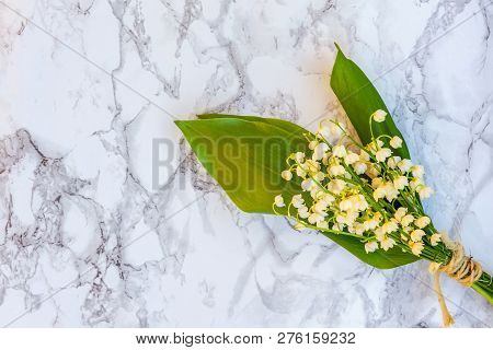 Bouquet Of Flowers Beautiful Smell Lily Of The Valley Or May-lily On Marble Background. Garden In Sp