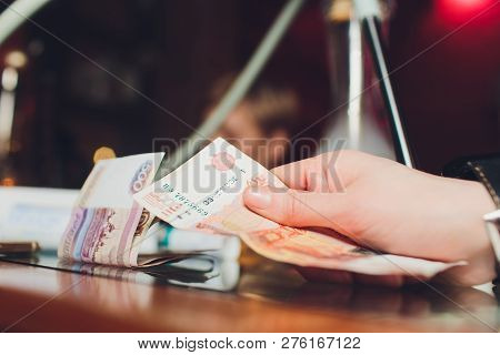 Russian Rubles In The Hand Of A Fan.male Hand Holding Many Of The Russian Banknotes.the Transfer Of 