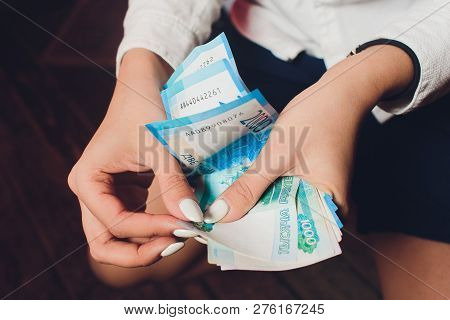 Russian Rubles In The Hand Of A Fan.male Hand Holding Many Of The Russian Banknotes.the Transfer Of 