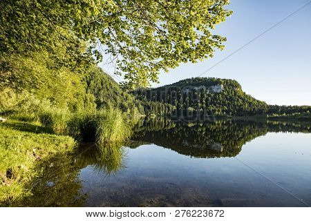 Scenic Reflection Of Forest In The Clear Lake At Bonlieu In The French Jura Region