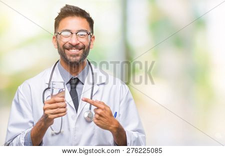 Adult hispanic doctor man drinking glass of water over isolated background very happy pointing with hand and finger