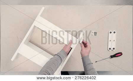 Man Collects Furniture In A Workshop. Stock. Bonding And Assembly Of Furniture On The Wooden Pins.