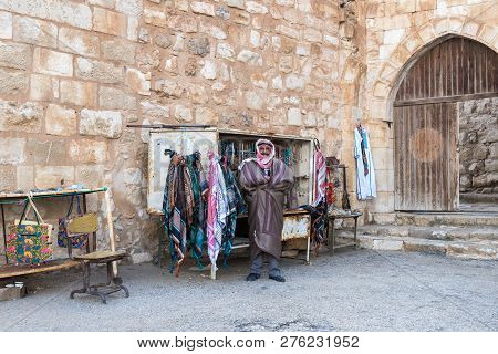 Al Jaya, Jordan, December 06, 2018 : The Seller - An Arab Stands Near His Shop With Souvenirs Near T