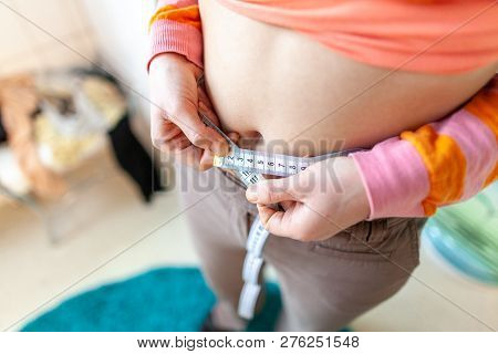Woman Measures Her Abdomen With A Measuring Tape